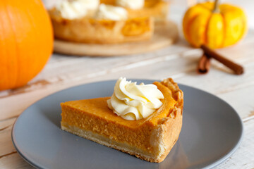 Traditional thanksgiving food on wooden table. Orange delicious homemade pumpkin pie with crust and decorative items. Thanksgiving table setting concept.Top view, close up, copy space, background.