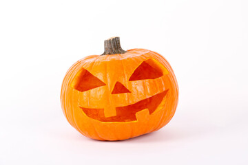 Orange pumpkin carved into creepy and funny Jack o Lantern isolated on white background. All hallows night. Copy space, close up, top view. Halloween party decoration. Trick or treat concept.