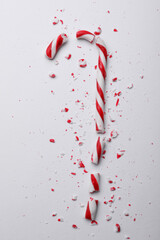 Broken sweet Christmas candy cane on white background, top view