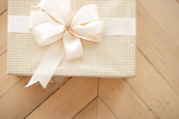 beautiful white Christmas box with a bow lies on the floor