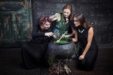 Young beautiful witches preparing a potion for Halloween 