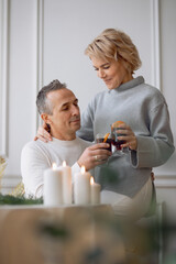 adult man and woman hugging sitting near a round festive table