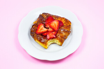 Bitten Puff pastry bun or roll. Cake with fresh strawberries. Delicious sweets temptation and...