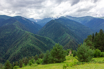 Fototapeta na wymiar Coniferous mountains of Svaneti under the clouds. Mestia, Heshkili.