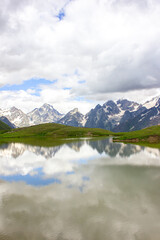 Naklejka na ściany i meble The Caucasus mountains and clouds are reflected in the mountain Koruldi lakes