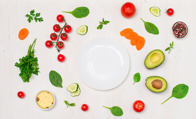 Healthy clean eating concept. Salad ingredients  around white plate on white background.