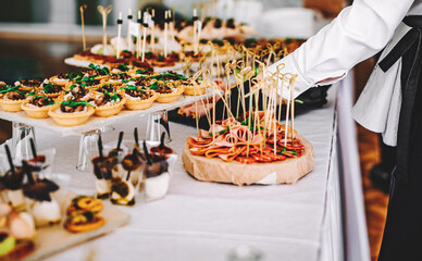 female hands of a waiter prepare food for a buffet table in a restaurant