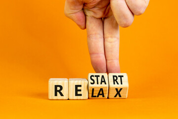 Relax and restart symbol. Businessman turns cubes and changes the word 'relax' to 'restart'. Beautiful orange table, orange background. Business, relax and restart concept. Copy space.