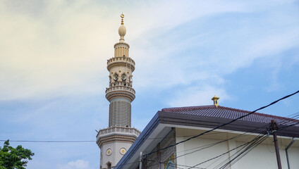Fototapeta na wymiar a skyscraper tower of the mosque with the dusk sky view. traditionally, the tower was for someone to call to prayer so can be heard from all directions.