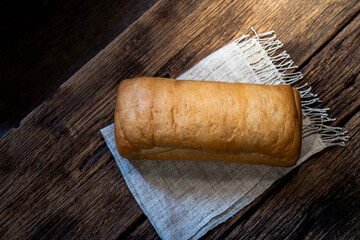 Fototapeta na wymiar loaf bread isolated on wood background.