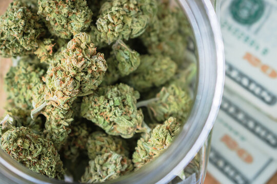 Marijuana Buds In Jar On Twenty Dollar Bills US Currency - View From Above Looking Down 