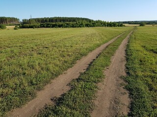 Dirt dirt road in a green field