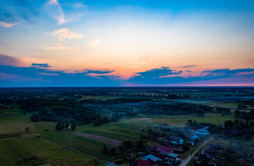 Drone hyperlapse above a misty village at dawn. Aerial view of the foggy countryside early in the morning. Quadrocopter flying over a small village at dusk, sunset. .