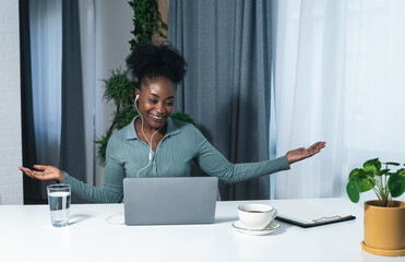 Young successful woman doctor of psychology sitting in a home office and gives a presentation online over the internet on a laptop computer explaining new methods of treating sick patients