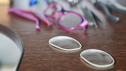 Optical technician work table. Close-up of lens frames and screwdrivers.