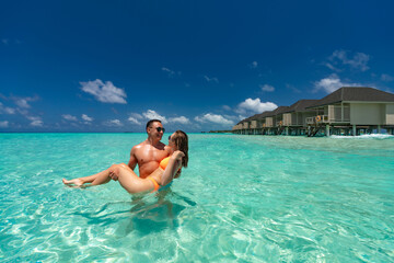 Young happy couple on tropical beach at summer vacation.