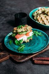 Belgian waffles with salmon, cucumber and egg in a plate