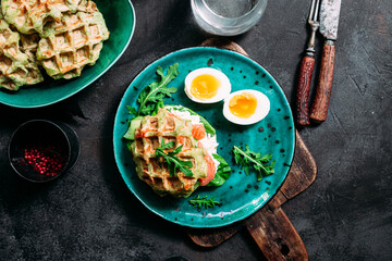 Belgian waffles with salmon, cucumber and egg in a plate