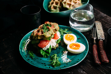 Belgian waffles with salmon, cucumber and egg in a plate