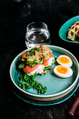 Belgian waffles with salmon, cucumber and egg in a plate