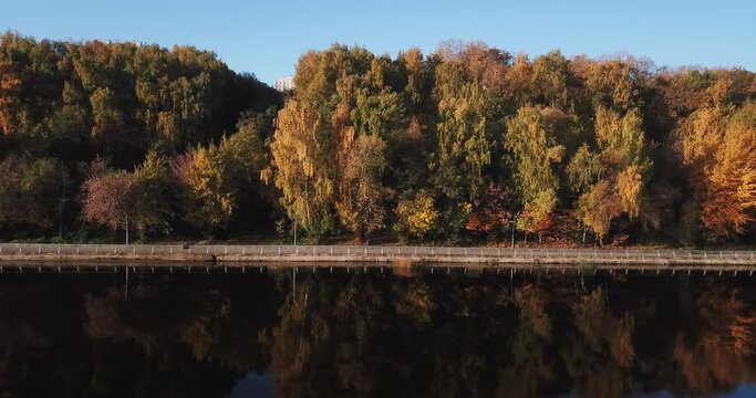 4K bright sunny autumn morning aerial drone video of Moscow River and yellow red forest park in Moscow, Russia