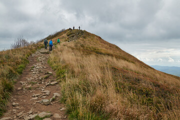Bieszczady jesienią. Turyści na górskich szlakach. Połoniny. Ciemne chmury. Korory jesieni. © Tomasz