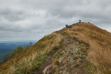 Bieszczady jesienią. Turyści na górskich szlakach. Połoniny. Ciemne chmury. Korory jesieni. © Tomasz