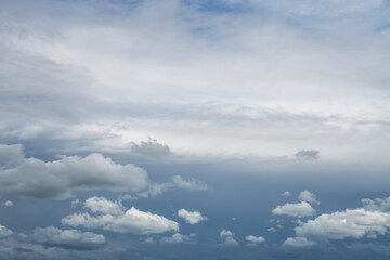 Replacement sky background or backdrop with beautiful fluffy white cumulus clouds below and altostratus clouds above with a dark blue sky showing through beyond.