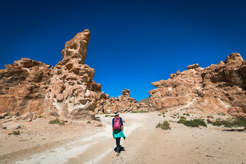 Fototapeta na wymiar A girl in a hat walks in the valley of stones. Bolivia