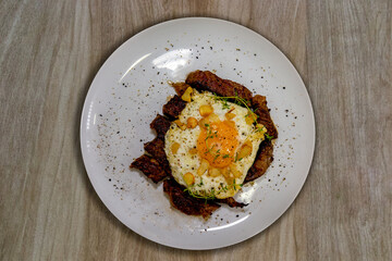 Traditional Brazilian ancho steak with a fried egg on top, known as 