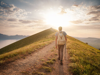 Young man travels alone walking on trail and enjoying on view of mountains and sea landscape at...
