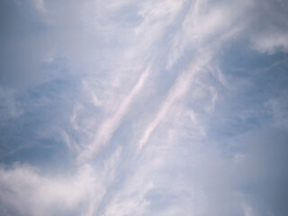 A fragment of the blue sky covered with white cirrus symmetrical clouds. Texture. Background.