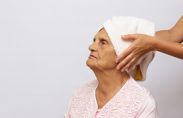 Older nice woman with towel on head after shower