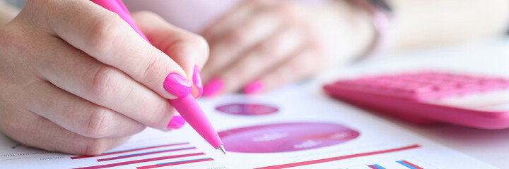 Woman examines business charts with commercial indicators in workplace