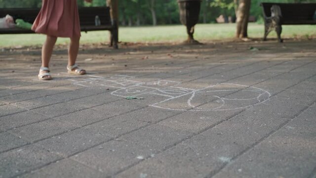 hopscotch girl. Little girl jumps in hopscotch in the yard. concept of childhood, games
