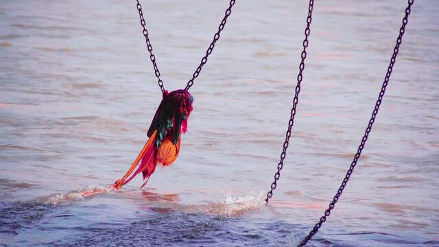 shot of colorful saffron orange cloth placed on a chain hanging into the ganga river at Haridwar to help people who fall in, placed as a mark of faith and decoration in this holy hindu spot