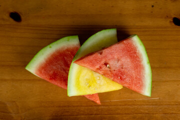 delicious overlapping colorful watermelon slices, cut in triangle on wooden table, top view photo and space for text