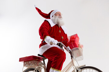 Santa Claus on bicycle delivering Christmas gifts.