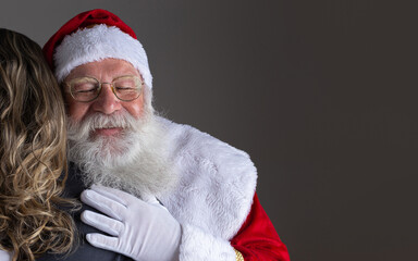 Happy Santa Claus hugging woman, gratitude and love on Christmas night.
