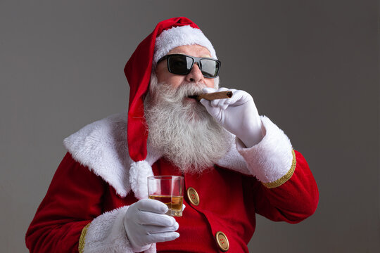 Santa Claus wearing sunglasses smoking a cigar and drinking whisk on dark background