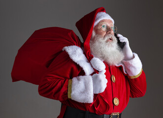 Santa Claus using a smartphone. Surprised.