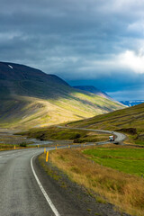 summer road trip on open hi-way  in Route 1 in Iceland with dramatic mountain landscapes on the background.
