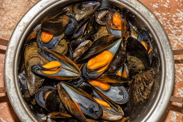 Stainless steel pan filled with steamed mussels