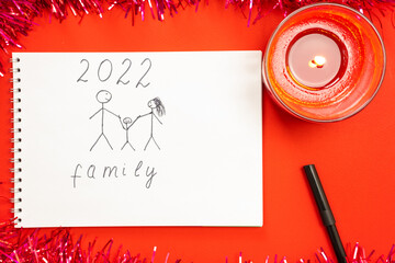 A red burning candle, on a red background and a picture of a child with a desire to live in a friendly, happy family.