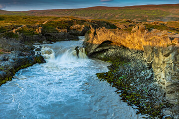 Fototapeta na wymiar dramatic sky during sunrise illuminating the powerful Godifoss waterfall in Iceland.