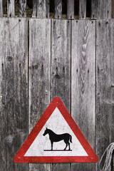 Triangular warning sign Attention horses on a wooden background
