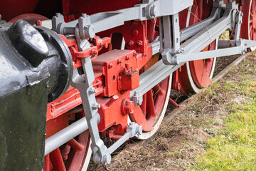 Resita, Romania, March 14, 2021: The big red wheels of an old locomotive from the 20th century are photographed in the locomotive museum in an industrial city