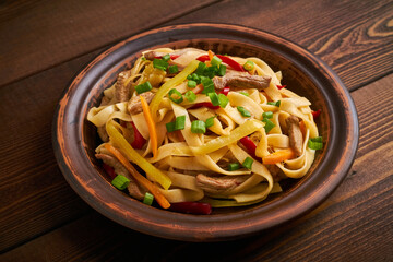 tsuivan traditional mongolian dish with meat vegetables homemade pasta wooden background