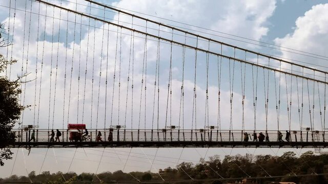 Ram Jula Bridge in Rishikesh, India. Travel to the Himalayas. Timelapse with running clouds over the bridge.