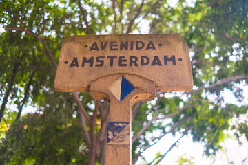 Amsterdam avenue sign with blurry tree as background